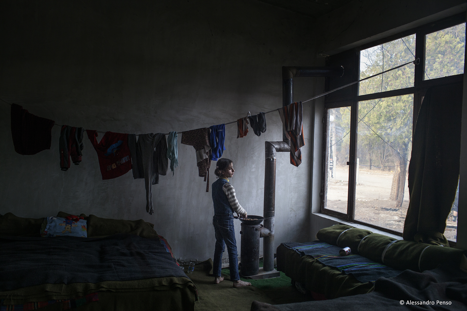 2013. Harmanli. Bulgaria. A young girl from Syria cooking inside the Harmanli camp. The biggest of Bulgaria’s “emergency centres” for refugees is in the town of Harmanli, about 30 kilometres away from the Turkish border, where around 1,000 asylum-seekers are being detained on a former military base, housed in tents, containers and a dilapidated building. People living in tents have no access to sanitation facilities. Although there are four toilets in a building at the entrance of the centre, they are frequently blocked and hardly adequate for hundreds of people. The tents are not heated and the residents sleep either on thin mattresses or on old foldable beds.